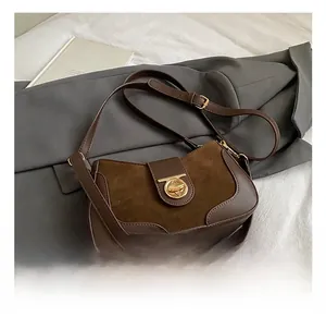 Detail view of brown vintage patchwork shoulder bag with golden metallic swivel clasp
