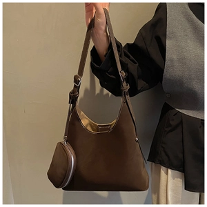 Detail of retro brown suede tote with crescent shape and small round coin purse charm