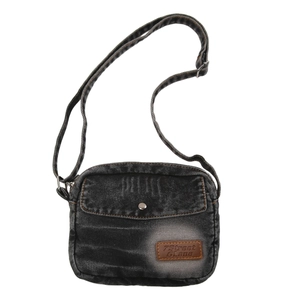 Détail d'un sac bandoulière en jean délavé avec poche avant et bouton-pression en métal