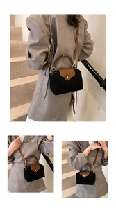 Detail of color-block nylon handbag featuring brown leather trim and golden metal clasp