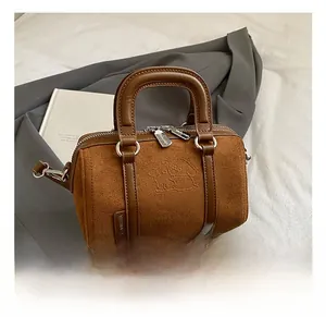 Detail of vintage brown frosted leather boston bag with embossed animal motif and logo