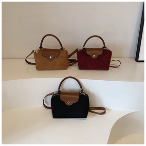 Detail of three nylon and suede crossbody bags in brown, wine red and black on steps