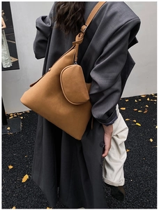 Detailed view of camel leather tote bag with a small pouch and adjustable strap on a model