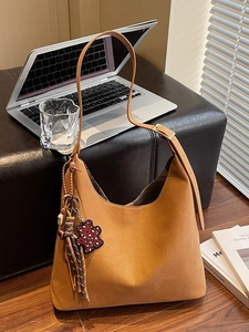 Minimalistische braune Hobo-Beuteltasche aus Leder mit Bärenanhänger und gewebtem Seil
