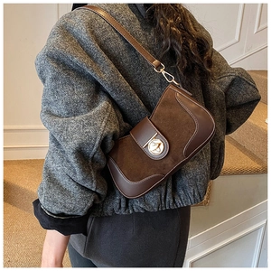 Detail of vintage brown suede crossbody bag with elegant gold metal buckle closure