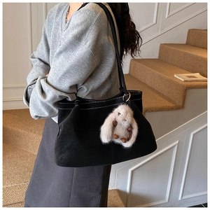 Large black suede tote bag with cute rabbit plush charm shown on a model for daily commute