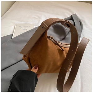 Détail du sac bandoulière en daim marron avec bandoulière en cuir et fermeture éclair en métal