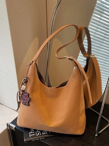 Minimalistische camelfarbene Hobo-Beuteltasche mit verstellbarem Gurt und Bärenanhänger