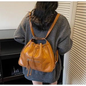 Detailed back view of a ginger leather bucket backpack with diamond-quilted stitching pattern
