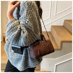 Detail of vintage brown suede barrel bag with embossed Snoopy design and mini waist pouch
