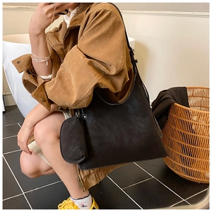 Detailed view of black suede tote bag with contrast stitching and attached coin purse