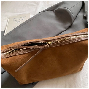 Vue détaillée du sac hobo en daim marron avec une longue tirette de fermeture éclair