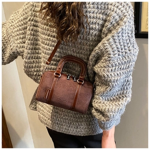 Detail of coffee suede barrel bag with embossed bunny and leather handle for women