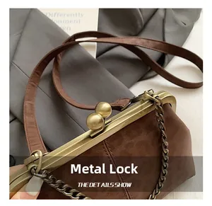 Détail du fermoir en bronze d'un sac coquillage léopard marron avec bandoulière en cuir