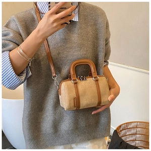 Close-up of beige suede boston bag featuring cute animal embossing and brown leather handles