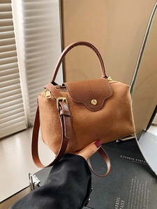 Brown suede Boston handbag with leather trim and gold hardware in natural light