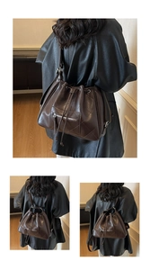 Detail of coffee brown bucket bag showing large diamond quilting and metal zipper