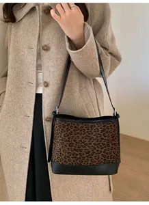 Close-up of leopard print shoulder bag with black leather trim and vintage metal buckle