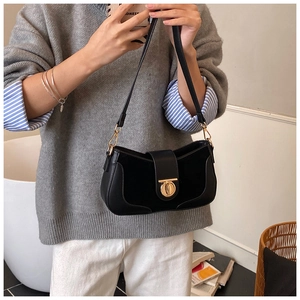 Detail of a black half-moon shoulder bag with a polished finish and gold metal buckle
