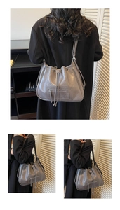 Detail of dark grey quilted PU leather tote bag with drawstring closure and zip pocket