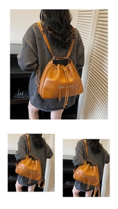 Close-up of quilted brown leather tote bag with drawstring and silver hardware detail