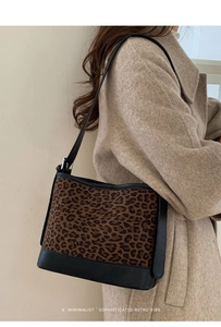 Detail of retro leopard print patchwork shoulder bag with leather strap on model