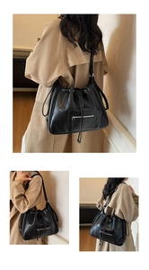 Detail of black quilted shoulder tote bag featuring soft leather texture and drawstring closure