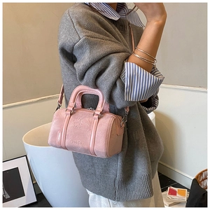 Detail of pink matte boston bag featuring embossed cartoon character and TuoTuo lettering