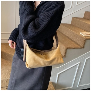 Détail du sac hobo en daim camel avec large bandoulière et finition texturée douce