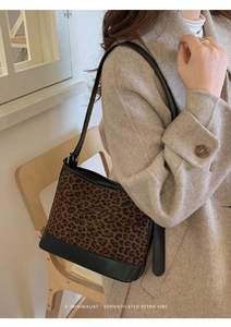 Detail shot of vintage leopard print shoulder bag with black leather trim and strap