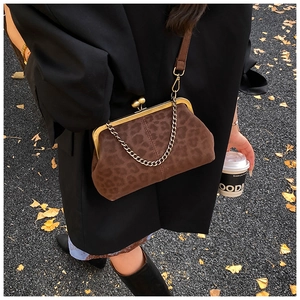 Detail of leopard print shell bag with vintage metal clasp and chain strap in natural light