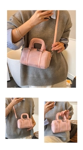 Detail of pink Boston bag showing matte leather texture, bear embossing, and metal studs
