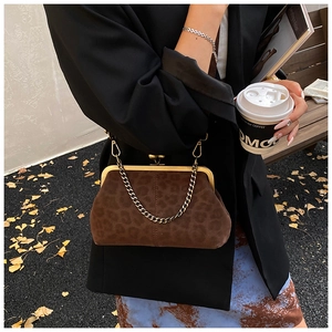 Chic leopard print frame bag with gold chain worn with black blazer and floral skirt