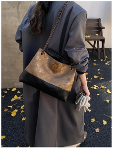 Detail view of the quilted stitching and metallic finish on the chain tote bag