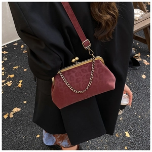 Détail d'un sac coquillage bordeaux à motif léopard avec fermoir doré et bandoulière