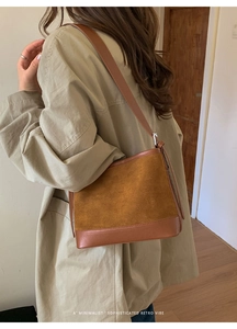 Detail of vintage brown suede and leather patchwork shoulder bag with metal buckle