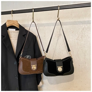 Detail of vintage suede shoulder bags in brown and black with round metal magnetic buckles
