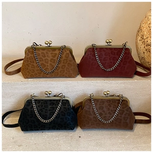 Retro leopard print shell bags in four colors arranged on grey steps with vintage chain straps