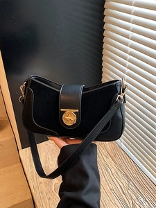 Minimalist black leather underarm bag with gold lock and textured patchwork design