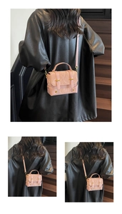 Detail of pink pleated messenger bag with gold hardware and leather shoulder strap
