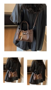 Close-up of brown pebbled faux leather bag featuring silver twist lock and bead charm