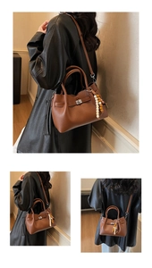 Detail of brown lychee grain leather bag with decorative beads and metal clasp