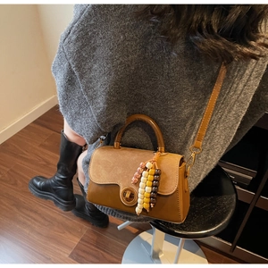 Detail of vintage crossbody bag with wooden handle, brown leather and suede textures