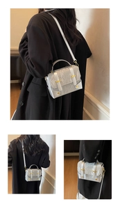 Detail of silver textured mini square bag with gold hardware and detachable strap