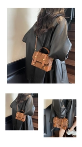 Detail of a brown pleated texture crossbody bag featuring golden buckles and adjustable strap