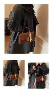 Detail of vintage brown leather handbag with gold rotary clasp and colorful bead tassel