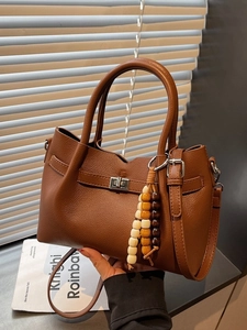 Dark brown textured leather square bag with silver clasp and wooden bead charm