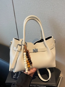 Chic beige crossbody bag with lychee texture leather and vintage beaded charm detail