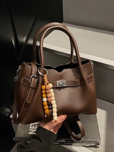 Dark brown pebbled leather crossbody bag with ethnic wooden bead charm and silver clasp