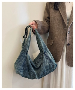 Detail of vintage denim shoulder bag with adjustable strap and buckle closure